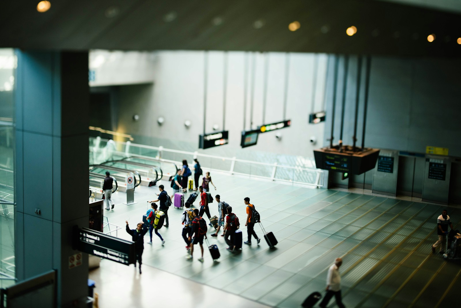 Travellers with suitcases walking through an airport terminal